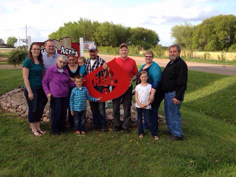 The Grazin' Acres family was recently presented with the REAL Seal as hosts of the 41st Annual Barron County Dairy Breakfast. Pictured from left to right: Tanya Roske and husband Josh Roske, REAL Seal presenter Janet Nelson, Liz Roske (holding Emmett Roske), Korbin Roske, Nathaniel Roske, presenter Kim Barta, Makenna Roske, Julie Roske, and Kevin Roske.